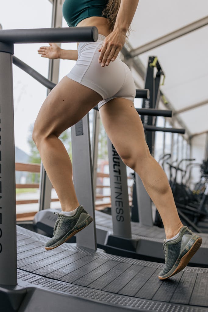 Focused runner working out on a treadmill in a modern indoor gym setting.